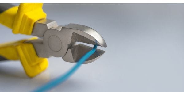 Electrical wire conducting electricity getting cut by scissors